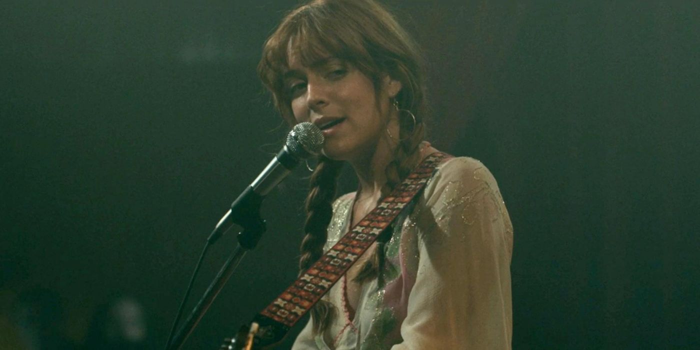 Daisy, played by Riley Keough, playing guitar and singing Two Against Three in Daisy Jones and the Six