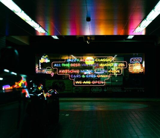 a subway station with neon signs on the wall