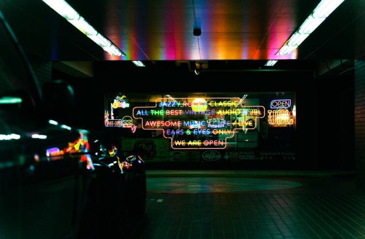a subway station with neon signs on the wall