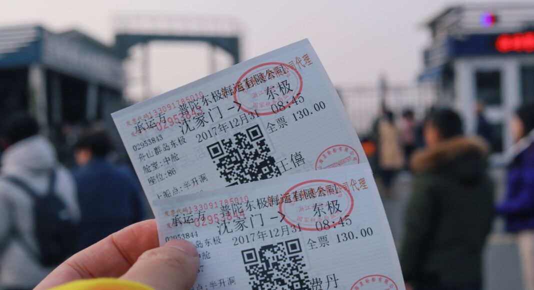 person holding two white tickets
