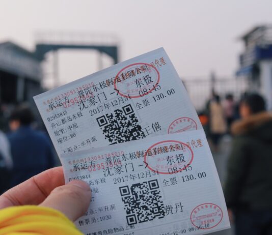 person holding two white tickets